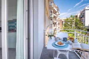 a table with a plate of food on a balcony at SorrentoVibes - Deluxe Apartment in Sorrento Centre in Sorrento