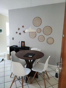 a dining room with a table and white chairs at Apartamento Vila do Sol in Blumenau