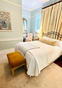 um quarto com uma cama grande e uma cadeira em Bijou Boutique Inn em Charleston