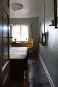 a bedroom with a bed and a table and a window at Cafe Sallys bed and breakfast in Ribe