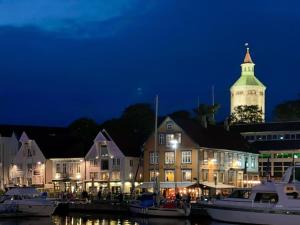 a building with a clock tower at night at Stavanger BnB 4 by Sidd in Stavanger