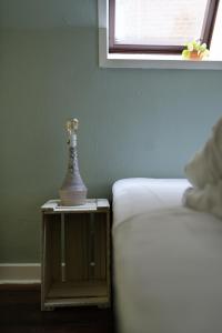 a table with a vase on it next to a bed at Cafe Sallys bed and breakfast in Ribe