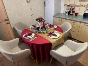 a table in a kitchen with a red table cloth at Flamingo House in Reghin