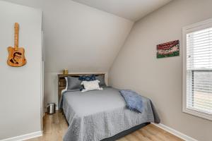 Un dormitorio con una cama y una guitarra en la pared en Tennessee Countryside Retreat with Private Deck, en Springfield
