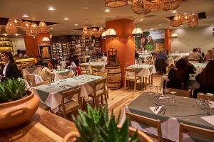 um restaurante com mesas e pessoas sentadas às mesas em Naindo Park Hotel em La Rioja
