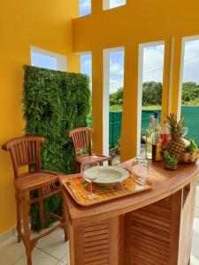 a table with two chairs and a table with wine glasses at Jeune Tournesol (Bungalow neuf) in Sainte-Anne