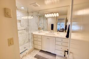 a white bathroom with a shower and a sink at Wildflower Resort Stay - Sun Valley Condo with King Bed and Mtn Views in Sun Valley +23 photos