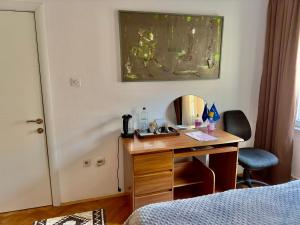 a hotel room with a desk and a bed and a mirror at Convini Bed & Bathroom Homestay in Prishtinë