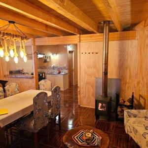 a dining room with a table and a wood stove at Cabañas rio Biobio in Callaqui