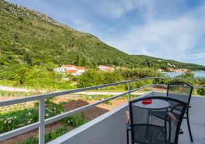 a chair on a balcony with a view of a mountain at Guest House Kukuljica 2 in Zaton