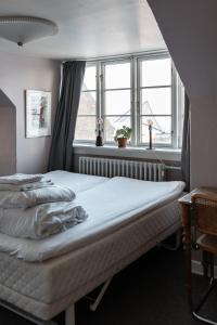 a bed sitting in a room with a window at Cafe Sallys bed and breakfast in Ribe