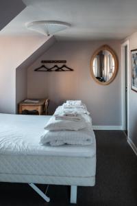 a bedroom with a white bed with a round mirror at Cafe Sallys bed and breakfast in Ribe