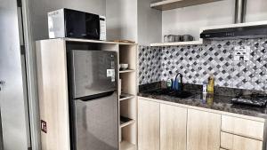 cocina con nevera de acero inoxidable y fregadero en SLEPTOPIA at THE NOVE NONGSA COZY HOOK PREMIUM UNIT WITH AMAZING VIEW, en Nongsa