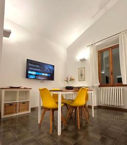 een eetkamer met een tafel en gele stoelen bij Appartamento Vecchia Farmacia 111 in Scarperia
