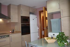 a kitchen with a table and a white refrigerator at Residentium Spain -Chalet la Dorada pets friendly in Cambrils