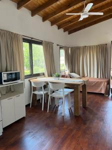 een woonkamer met een tafel en stoelen en een bed bij Algarrobos del Mirador in Santa Rosa de Calamuchita