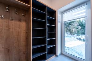 a book shelf in a room with a window at Apartmán SPORT in Pernink