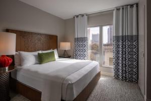 a bedroom with a large bed and a large window at Hotel Contessa - Suites on the Riverwalk in San Antonio