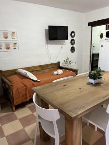 een slaapkamer met een bed, een houten tafel en een bureau bij Algarrobos del Mirador in Santa Rosa de Calamuchita