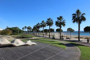 a park with a sculpture and palm trees and a beach at Residentium Spain -Chalet la Dorada pets friendly in Cambrils