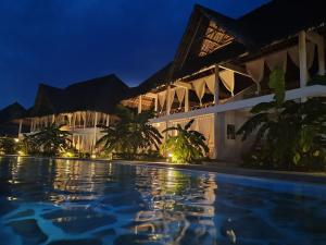 un resort con piscina por la noche en Kupenda House - Milele Resort Tamu, Watamu, en Watamu