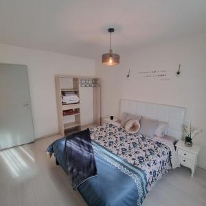 1 dormitorio con 1 cama con edredón azul en LA DOLCE VITA, en Oyonnax