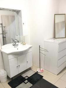 Baño blanco con lavabo y espejo en Ferienwohnungen Honberg, en Tuttlingen