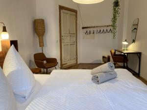 - une chambre avec un lit blanc et des serviettes dans l'établissement Minimal Hostel No 41, à Berlin