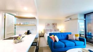 uma sala de estar com um sofá azul num quarto em S&N Lux Suite-Free Parking-King Bed-Kitchen-WiFi em Honolulu