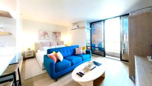 a living room with a blue couch and a table at S&N Lux Suite-Free Parking-King Bed-Kitchen-WiFi in Honolulu