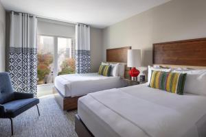 een hotelkamer met 2 bedden, een stoel en een raam bij Hotel Contessa - Suites on the Riverwalk in San Antonio