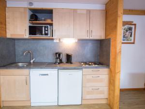 a kitchen with white cabinets and a sink at Appartement Aussois, 2 pièces, 4 personnes - FR-1-508-37 in Aussois