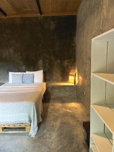 1 dormitorio con cama y estante en Pachamama Tropical Garden Lodge en Carmen
