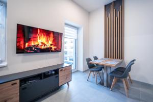 a living room with a fireplace and a table with chairs at Apartmán SPORT in Pernink