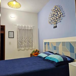 um quarto com uma cama com um edredão azul em Villa Mar a Vista - Suite Alamanda em Cumuruxatiba