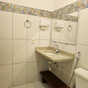 a bathroom with a sink and a toilet at Villa Mar a Vista - Suite Alamanda in Cumuruxatiba