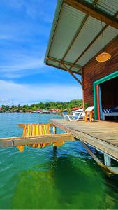a dock with a house on a body of water at The Sea Monkey in Bocas del Toro