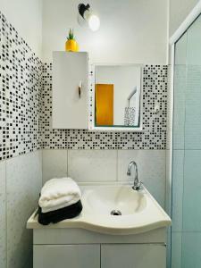 a bathroom with a sink and a mirror at Kitnet no coração de Serra Negra in Serra Negra