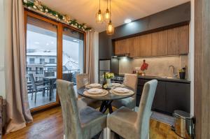 a kitchen and dining room with a table and chairs at Apartman Kostić in Zlatibor