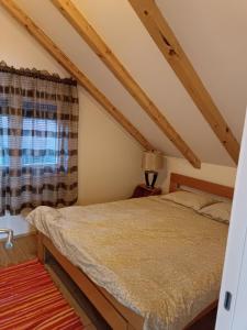 Schlafzimmer mit einem Bett und einem Fenster in der Unterkunft Naš san in Vrdnik