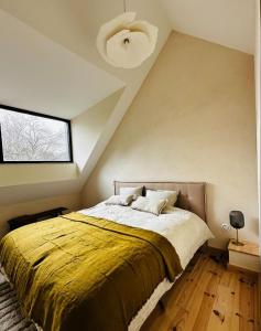 a bedroom with a large bed with a yellow blanket at la madrague des 2 caps in Audembert