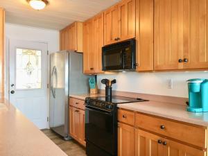 een keuken met houten kasten en een zwarte kachel bij Breezy Point Hideout BY Betterstay in Saratoga Shores