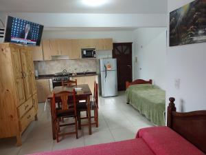 a kitchen with a table and a room with a bed at Apartamentos David in Ostende