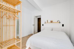 um quarto com uma cama branca e um espelho em La Casa del Granado em Toledo