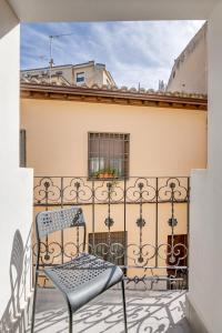 een stoel op het balkon van een gebouw bij La Casa del Granado in Toledo