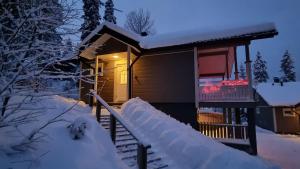a cabin in the snow at night at Villa Magnolia 1 Himos in Jämsä