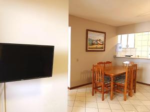 a dining room with a table and a flat screen tv at 206-CDB Dpto a 100m del mar de Bombas in Bombinhas