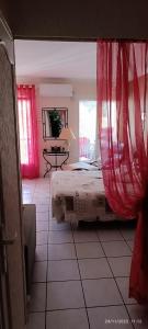 1 dormitorio con 1 cama con cortinas rojas en Loratori, en Amélie-les-Bains-Palalda