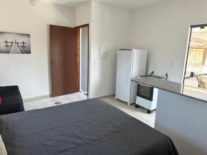 apartamento Praia do Campeche, Jardim Eucaliptos في فلوريانوبوليس: غرفة بسرير وثلاجة