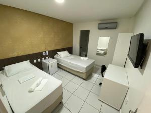 阿拉皮拉卡的住宿－Falcão Hotel Arapiraca，酒店客房设有两张床和电视。